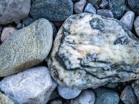 Mehrfarbiger Stein neben strukturiertem graubraunem Stein